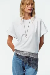 Camiseta blanca de algodón con cuello redondo y mangas cortas con vuelta, trabilla y botón.