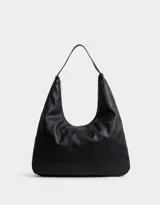 Bandolera hobo de cuerina color negro, con manija superior y cierre superior.
