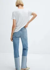 Remera blanca de corte recto, con cuello en V y mangas cortas.