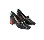 Mocasines negros de charol texturizado con punta cuadrada, detalle de hebilla dorada y tacón geométrico de madera.