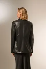 Blazer negro de eco-cuero, con cuello solapa, bolsillos frontales y cierre con botón.