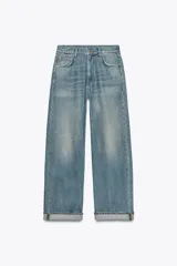 Pantalón de jean celeste de tiro medio, corte ancho y efecto lavado. Tiene cinco bolsillos, trabillas en la cintura y ruedo con dobladillo.