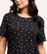 Conjunto de pijama negro con estampado de lunares, caritas sonrientes y la palabra "love". Incluye una blusa de mangas cortas y un short con cintura elastizada.
