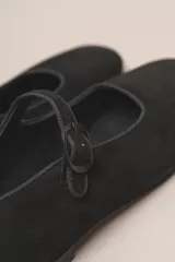 Zapato estilo Mary Jane color marrón, de cuero, con punta redondeada y tira sobre el empeine con hebilla.