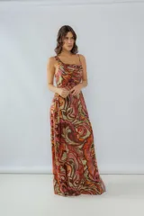 Vestido largo de seda de algodón estampada con detalles en hilo dorado, escote cuadrado con un bretel fino y otro ancho, tableado sutil en la parte delantera, lazo al costado y tajo.