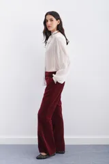 Pantalón de terciopelo color borgoña, estilo oxford, con acceso por cartera oculta con cierre, gancho metálico y botón interno en cintura. Bolsillos diagonales y bolsillo ojal en espalda.