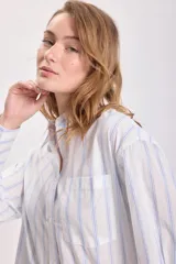 Camisa blanca con rayas verticales celestes, de corte clásico y manga larga.