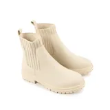Bota corta color hueso de símil cuero, con panel elástico en los laterales, lengüeta en el talón y base con taco bajo.