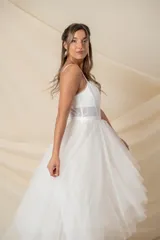 Vestido largo de tul color marfil, con corsé con ballenas y cintura transparente, breteles finos y falda de tul en capas.