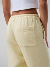 Pantalón de gasa doble color amarillo pálido, de corte recto y cintura elástica con cordones.
