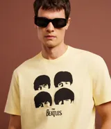 Remera color amarillo claro de algodón con cuello redondo y mangas cortas. Estampa frontal con los rostros de los integrantes de The Beatles y el logo de la banda.