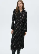 Vestido midi camisero negro con estampado de lunares color beige, cierre frontal con botones, lazo en la cintura y mangas largas con puños abotonados.