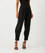 Pantalón zanahoria de crepé negro con pliegues, corte de sastrería, trabillas en la cintura y abertura con botón y cremallera.
