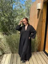 Vestido largo azul marino de lino con cuello mao, escote en V, mangas 3/4 con volados y corte escalonado. Diseño amplio y cómodo.