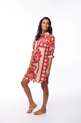 Vestido corto tipo camisero con botones al frente y mangas cortas con elástico y volado. Estampado con flores rojas y beige.