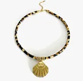 Gargantilla con cordón estampado animal print y dijes dorados con diferentes motivos: concha, sol, corazón, golondrina, pez y palmera.