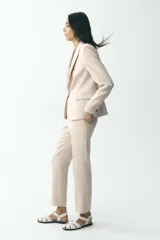 Blazer negra de corte clásico, con cuello solapa, manga larga, bolsillos frontales con solapa y cierre frontal con un botón.