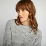 Sweater gris de punto grueso con cuello alto y mangas largas.