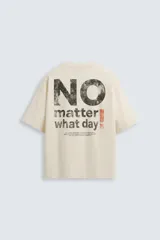 Camiseta color crema de corte cuadrado, con cuello redondo y mangas cortas. Estampado frontal con la frase "no matter what day" en letras pequeñas de color negro.