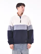 Buzo de polar con cierre parcial y cuello alto, con diseño a bloques de color: blanco, gris y azul marino.