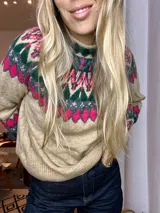 Sweater de tejido de punto color beige con cuello alto y diseño jacquard en tonos verde oscuro y fucsia en el canesú.