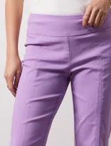 Pantalón verde esmeralda de gabardina elastizada, con pretina ancha y faja interna modeladora. Tiene costuras verticales pespunteadas en el frente y bolsillos ojal simulados en la parte trasera.