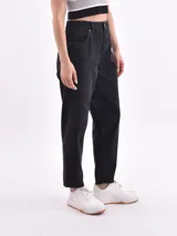 Pantalón de jean negro, corte mom fit, tiro alto y bolsillos delanteros y traseros.