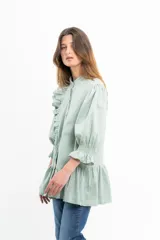 Blusa con volantes en los hombros, de corte holgado y color aguamarina.