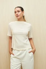 Top color crema de textura acanalada, con cuello semi alto y mangas cortas.