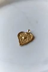 Collar con tiento encerado negro y dije dorado con forma de corazón texturizado.