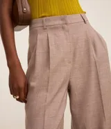 Pantalón de vestir color beige con cintura sencilla, pliegues delanteros y corte palazzo.