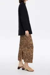Falda midi de corte recto y ajustado, con estampado animal print en tonos marrones y negros. Presenta goma elástica en la cintura y abertura trasera en el bajo.