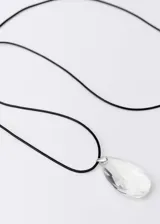 Gargantilla con cordón negro ajustable y dije de cristal facetado en forma de lágrima.