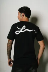 Remera negra de corte regular fit, con un pequeño parche ovalado estampado en el pecho y un gran logo de estilo manuscrito en la espalda.