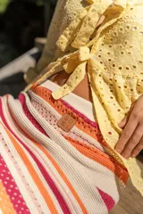 Pollera midi tejida a rayas horizontales en tonos beige, naranja, fucsia y gris.