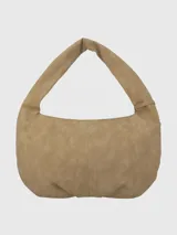 Cartera tipo hobo color beige de gamuza sintética con tachas doradas en el borde. Tiene un asa de hombro y un dije colgante con el logo de la marca.