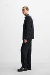 Pantalón de vestir negro slim fit confeccionado en tejido de lana de origen italiano. Cuenta con bolsillos frontales y traseros de vivo con botón. Cierre frontal con cremallera y botón. Colección especial Origins.