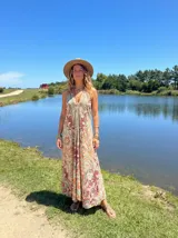 Vestido largo estampado paisley en tonos terracota, beige y turquesa. Diseño con escote halter y caída fluida.