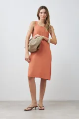 Vestido midi de lino color durazno, corte recto y sin mangas.