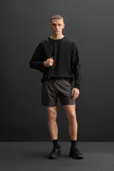 Shorts deportivos color gris oscuro confeccionados en tejido técnico ligero y elástico con forro interior, cintura elástica ajustable con cordón, bolsillos laterales, bolsillo de seguridad en espalda con cierre de cremallera, bajo con aberturas laterales y detalle de logo estampado en pernera.