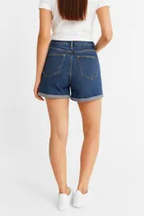 Short de jean negro con lavado gastado, tiro alto, corte ajustado y ruedo doblado.