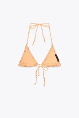 Top de bikini triangular color durazno con estampado de flores rojas y ribete de puntilla. Se ata al cuello y a la espalda con lazos finos.
