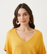 Blusa de punto color mostaza, con escote en V y mangas cortas.