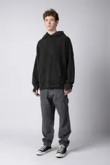 Buzo canguro verde con efecto desgastado, capucha con cordón ajustable, bolsillo frontal y puños con orificio para el pulgar.