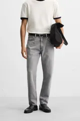 Pantalón de jean celeste de corte slim fit y tapered, con cinco bolsillos, efecto lavado y cierre frontal con cremallera y botón.