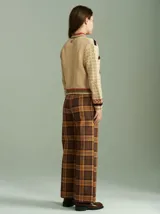 Cardigan de punto color beige con cierre frontal, cuello tortuga y mangas largas holgadas. Presenta diseño con distintas texturas, tejido en ochos a los lados del cierre y apliques de corazones de tela bordados. Confeccionado en 100% algodón.