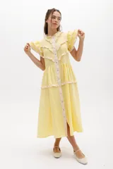 Vestido midi amarillo de lino, con cuello mao, mangas cortas con volados, corte imperio y falda escalonada con volados.