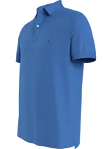 Chomba azul de Tommy Hilfiger, modelo 1985, de corte regular, con cuello tipo chomba, cartera de dos botones, logo bordado en el pecho y confeccionada en mezcla de algodón y poliéster.