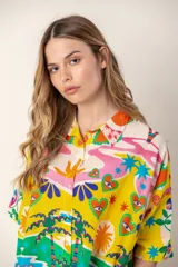 Camisa color crema con estampado de palmeras rosas, de corte recto y manga corta.