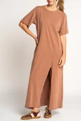 Vestido largo color visón de algodón con cuello redondo y mangas cortas. Presenta un tajo alto en el frente.